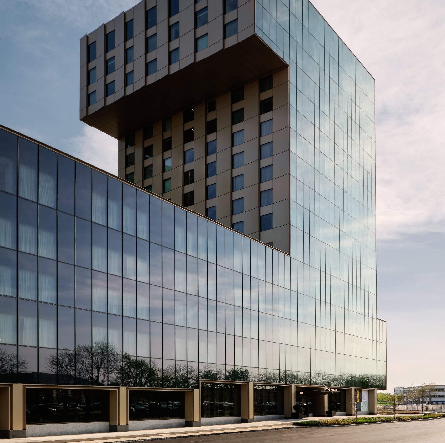 View of The Atlas hotels glass facade at street level