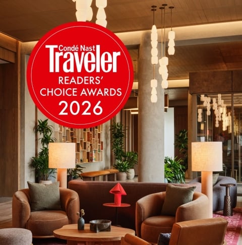 Large red circular sign reading 'Condé Nast Traveler Readers' Choice Awards 2026' in a modern hotel lobby.